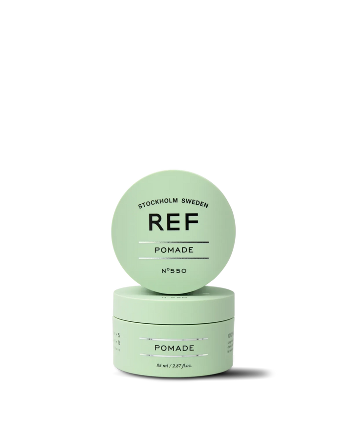 Official REF Stockholm front/hero product shot of Pomade N°550 (85ml) - closed jar with lid propped against the jar, showing the mint-green packaging and REF logo. Source: refstockholm.com official product page (og:image).